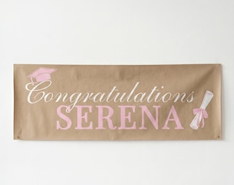 May include: A brown banner with the words "Congratulations SERENA" in white and pink lettering. A pink graduation cap and diploma illustration are on the banner. The banner is rectangular and has a light background.
