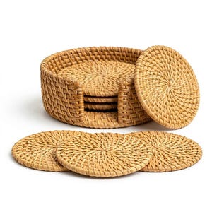 May include: A set of woven rattan coasters and a matching holder. The coasters are round with a woven pattern and a light brown color. The holder is a basket-like structure, also made of woven rattan.
