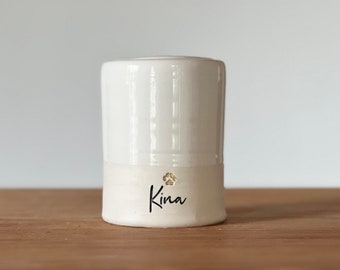 Custom pet urn or person urn for ashes. white personalized cursive name shown with gold paw