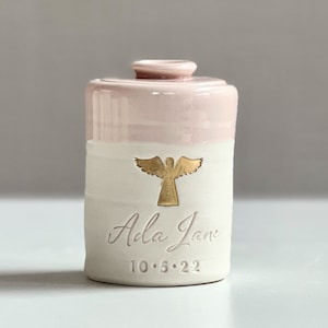 custom infant urn or child urn. Angel urn for ashes. Baby girl memorial urn shown in pink. By vitrifiedstudio