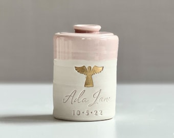 custom infant urn or child urn. Angel urn for ashes. Baby girl urn shown in pink. By vitrifiedstudio