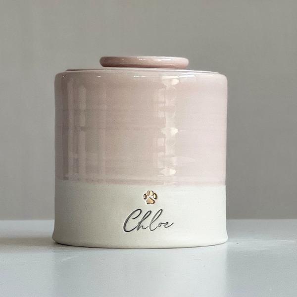 Custom pet urn for ashes. pink personalized cursive name shown with gold paw vitrifiedstudio