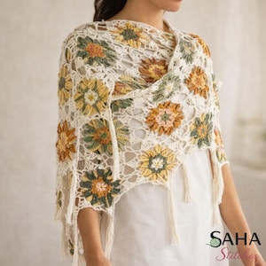 Può includere: Sciarpa all'uncinetto color crema con motivi floreali nei toni del giallo, arancione e verde. La sciarpa ha un bordo con frange ed è drappeggiata sulle spalle. Il design floreale è una caratteristica chiave di questo accessorio fatto a mano.