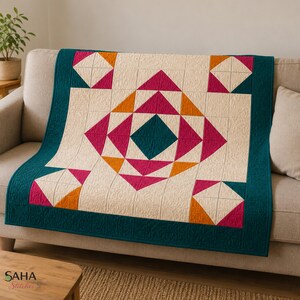 May include: A quilt featuring a geometric pattern with a central teal diamond surrounded by magenta and orange triangles on a cream background. The quilt is framed by a wide teal border and displays intricate quilted stitching throughout the fabric.
