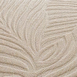 May include: Close-up of a beige rug with a leaf pattern. The design features curved lines that create a textured, three-dimensional effect. The rug's neutral color and detailed pattern suggest a focus on home decor.