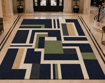 May include: A rectangular area rug featuring a geometric pattern of intersecting lines and blocks in navy blue, cream, sage green, and tan. The design consists of solid-colored rectangles and squares arranged in a structured, grid-like composition.