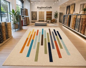 May include: A rectangular area rug with a cream-colored background featuring a pattern of vertical stripes in varying lengths and colors, including orange, yellow, light blue, dark blue, brown, and green, displayed on a light wood floor.