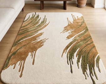 May include: Cream-colored area rug with a unique design. The rug features abstract, feather-like patterns in shades of brown and green, creating a textured, artistic look. The rug is placed on a wooden floor, adding warmth to the room.