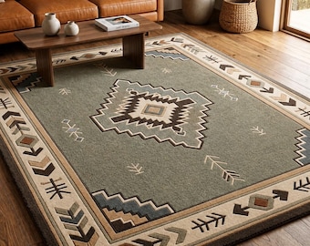 May include: A rectangular area rug featuring a sage green field with a central geometric diamond motif in shades of brown, cream, and blue. The border displays a repeating pattern of stylized arrows and chevron shapes in earth tones.
