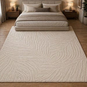 May include: A beige rectangular rug with a leaf pattern is in front of a bed. The rug has a textured surface with a repeating design of curved lines resembling leaves. The bed has a beige headboard and bedding.