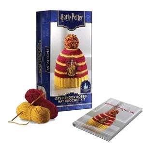 May include: A Harry Potter Gryffindor bobble hat crochet kit featuring a box with a finished red and yellow striped hat with a pom-pom, two skeins of yarn in red and yellow, and an instruction booklet with a picture of the finished hat.