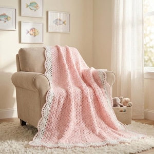 May include: A soft pink crocheted blanket with a white scalloped border draped over a beige upholstered armchair. The blanket features a textured, repeating stitch pattern throughout its length, providing a cozy and layered appearance on the seat.