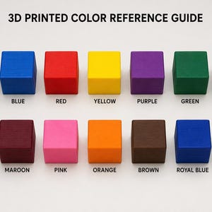 May include: A 3D printed color reference guide featuring a series of small, square blocks in various colors. The blocks are labeled with color names such as black, blue, red, yellow, purple, green, grey, dark grey, maroon, pink, orange, brown, royal blue, and teal.