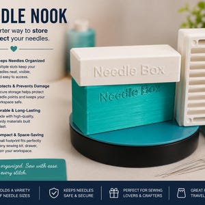 May include: A teal and white Needle Nook needle storage box with the text "Needle Box" embossed on the lid and side. A white needle holder is to the right. The text "NEEDLE NOOK" is at the top.