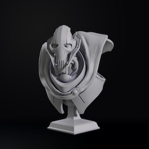 May include: A gray bust of a character with a distinctive helmet and mechanical features, set against a dark background. The bust includes a cape-like garment and is mounted on a square pedestal. The overall design suggests a science fiction or fantasy theme.