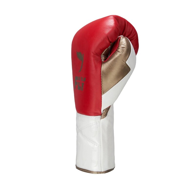 Op de afbeelding: Een bokshandschoen met een rood bovengedeelte, een metallic goudkleurig middenpaneel en een wit gedeelte bij de pols. Op het rode gedeelte staat een donker logo met de tekst FJI. De handschoen is opgebouwd uit gestikte panelen met een gladde afwerking.