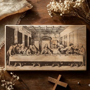 May include: A rectangular wooden plaque featuring a detailed engraving of The Last Supper. The artwork depicts Jesus and his disciples seated at a long table. The plaque is light brown with dark brown engraved details.