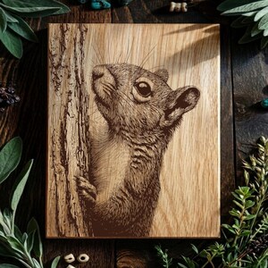 May include: A rectangular wooden plaque featuring a detailed dark brown laser-engraved illustration of a squirrel clinging to the side of a tree trunk. The natural wood grain is visible throughout the surface, highlighting the texture of the bark.