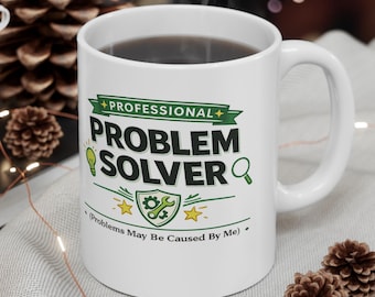 May include: A white ceramic mug featuring the text "PROFESSIONAL PROBLEM SOLVER" in bold black letters, accompanied by green icons of a lightbulb, a magnifying glass, and a shield with a wrench and gear, plus the text "Problems May Be Caused By Me".