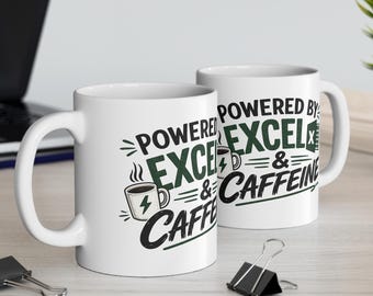 May include: Two white ceramic mugs featuring the black and green text "POWERED BY EXCEL & CAFFEINE" along with a graphic of a coffee cup with a lightning bolt symbol. The mugs are positioned on a desk surface with office supplies nearby.