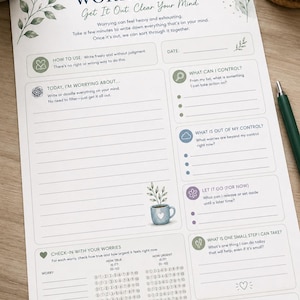 Könnte beinhalten: Ein weißes Arbeitsblatt mit dem Titel Worry Dump, bedruckt mit dunkelblauem und salbeigrünem Text sowie botanischen Illustrationen. Es enthält Abschnitte zum Aufschreiben von Sorgen, zur Kontrolle und zur Verfolgung von Gefühlen.