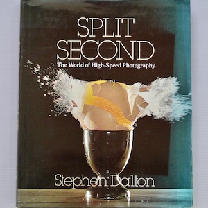 May include: Book cover titled "Split Second" with the subtitle "The World of High-Speed Photography." The cover features an egg exploding in a dark egg cup, with the author's name, Stephen Dalton, at the bottom.