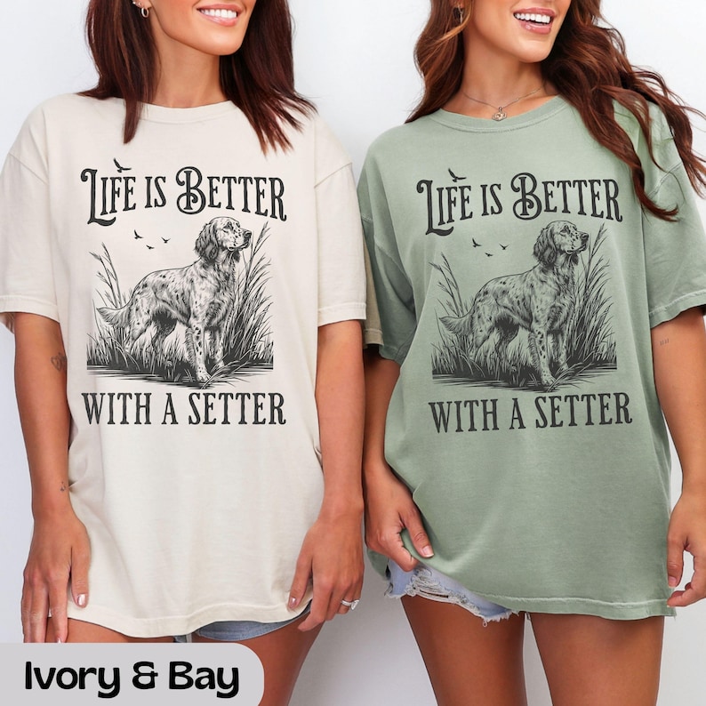 May include: Two t-shirts, one ivory and one bay green, with the text "Life is Better With a Setter." The graphic features a detailed illustration of a setter dog in tall grass. The shirts are a relaxed fit.