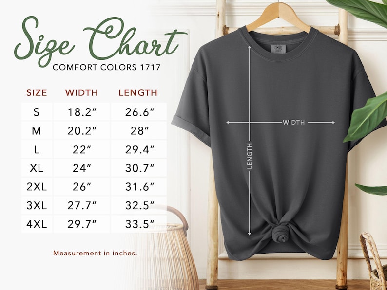 May include: A dark gray t-shirt displayed on a wooden hanger, with a size chart showing measurements in inches. The chart includes sizes S to 4XL, with corresponding width and length measurements. The text "Size Chart" is at the top.