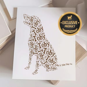 May include: A white card featuring a brown silhouette of a dog composed of the name "Toby" repeated. A gold and black "Exclusive Product" seal is in the upper right corner. The card is on a white surface.