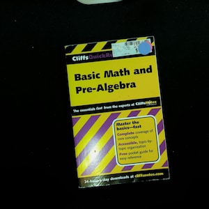 May include: A CliffsQuickReview Basic Math and Pre-Algebra study guide with a yellow and purple striped cover. The text reads: CliffsQuickReview, Basic Math and Pre-Algebra, The essentials fast from the experts at CliffsNotes, Master the basics-fast.