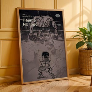 May include: Framed poster featuring a black and white illustration of a boxer in a boxing ring. The poster includes the text "Hajime No Ippo" and other Japanese text. The artwork is set in a wooden frame.