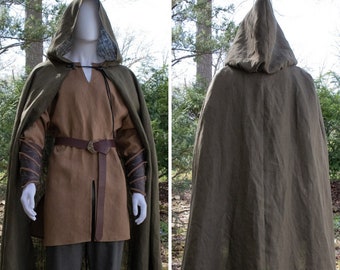 May include: A green hooded cloak made of linen fabric. The cloak is worn over a brown tunic and pants. The cloak has a hood that can be pulled up over the head.