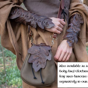 May include: A brown leather bag with leaf-shaped details. The bag is worn over the shoulder and has a strap with a metal clasp. The bag is also available as a cross body bag. Leaf arm bracers are sold separately.