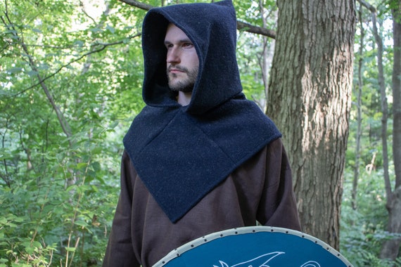 Uma mulher em uma fantasia de viking fica na chuva.