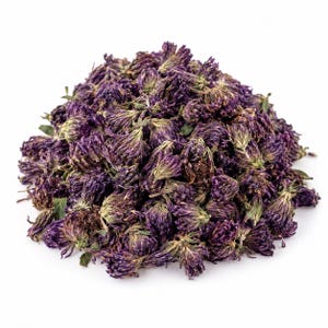 Puede incluir: Un montón de flores de trébol secas de color púrpura. Las flores individuales están agrupadas estrechamente, mostrando tonos violeta intenso y púrpura oscuro con pequeños toques de tallos verdes y follaje seco visibles en el montón.