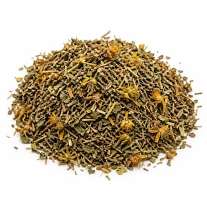 May include: A close-up of a heap of dried herbs and flowers, predominantly green with yellow highlights. The mixture comprises leaves, stems, and small flower heads, indicating a herbal tea or medicinal blend. The backdrop is a simple white surface.