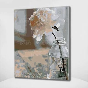 Op de afbeelding: Schilderij van een witte en perzikkleurige pioenroos in een heldere glazen fles. De fles is gedeeltelijk gevuld met water en staat op een tafel. De achtergrond is een zacht, neutraal kleurenpalet met de tekst "PAINTING EXPERT" herhaald.