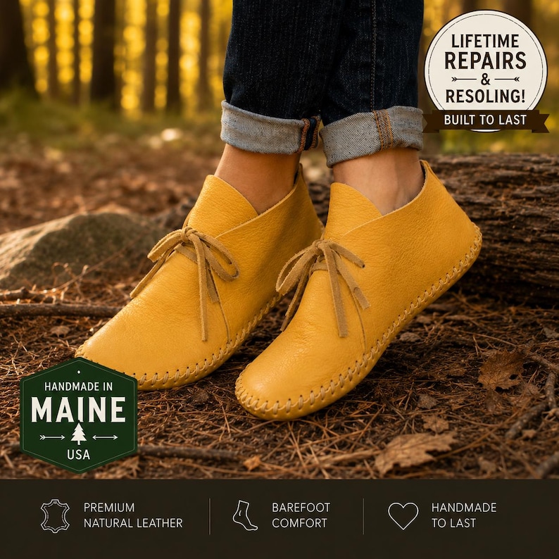 May include: A pair of mustard yellow leather moccasins with thin laces and visible whipstitch detailing along the sole. The shoes are worn with cuffed dark blue jeans. Text overlays include "HANDMADE IN MAINE" and "LIFETIME REPAIRS & RESOLING!"