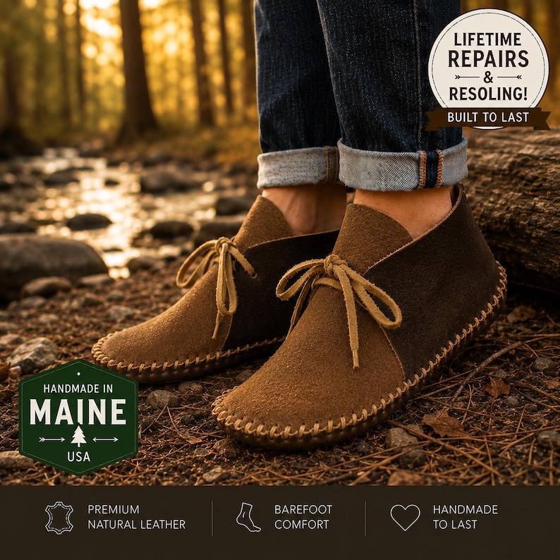 May include: Brown suede ankle boots with a moccasin-style construction, featuring light tan laces and visible whipstitching along the sole. The boots are worn with cuffed blue jeans. Text overlays include 'Handmade in Maine' and 'Lifetime Repairs'.