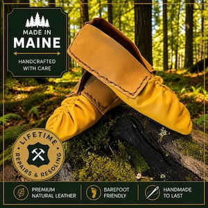 May include: A pair of mustard yellow leather moccasins with a folded cuff and visible stitching. The text on the image reads: MADE IN MAINE, HANDCRAFTED WITH CARE, LIFETIME REPAIRS & RESOLING, PREMIUM NATURAL LEATHER, BAREFOOT FRIENDLY, HANDMADE TO LAST.