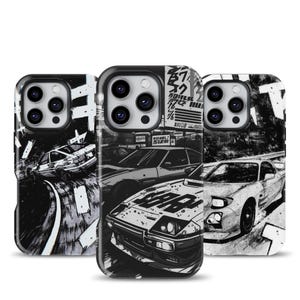 Peut inclure: Trois coques de téléphone avec des illustrations en noir et blanc de voitures de sport japonaises. Les coques présentent différents modèles de voitures et des scènes de rue, avec des accents de texte japonais. Les motifs sont de style manga ou anime.