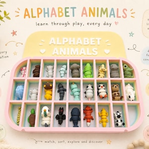 Könnte beinhalten: Ein rosa-gelbes Alphabet-Tier-Spielzeugset. Das Set enthält eine Schale mit einzelnen Fächern, in denen jeweils eine kleine, farbenfrohe Tierfigur untergebracht ist. Der Text "ALPHABET ANIMALS" wird über der Schale angezeigt und fördert das spielerische Lernen.