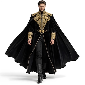 May include: A black velvet coat with gold embroidery. The coat features a high collar and ornate gold detailing on the shoulders, cuffs, and front. The coat has a long cape and is paired with black pants and boots. The overall style is regal and theatrical.