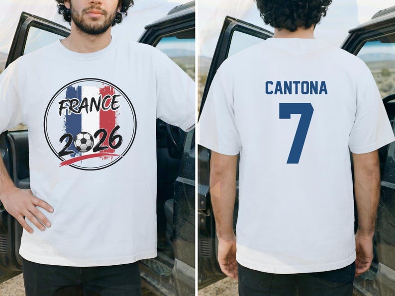 Puede incluir: Camiseta blanca con un gr&aacute;fico en la parte delantera que presenta los colores de la bandera francesa, un bal&oacute;n de f&uacute;tbol y el texto "FRANCE 2026". La parte trasera de la camiseta muestra el nombre "CANTONA" y el n&uacute;mero "7" en azul.
