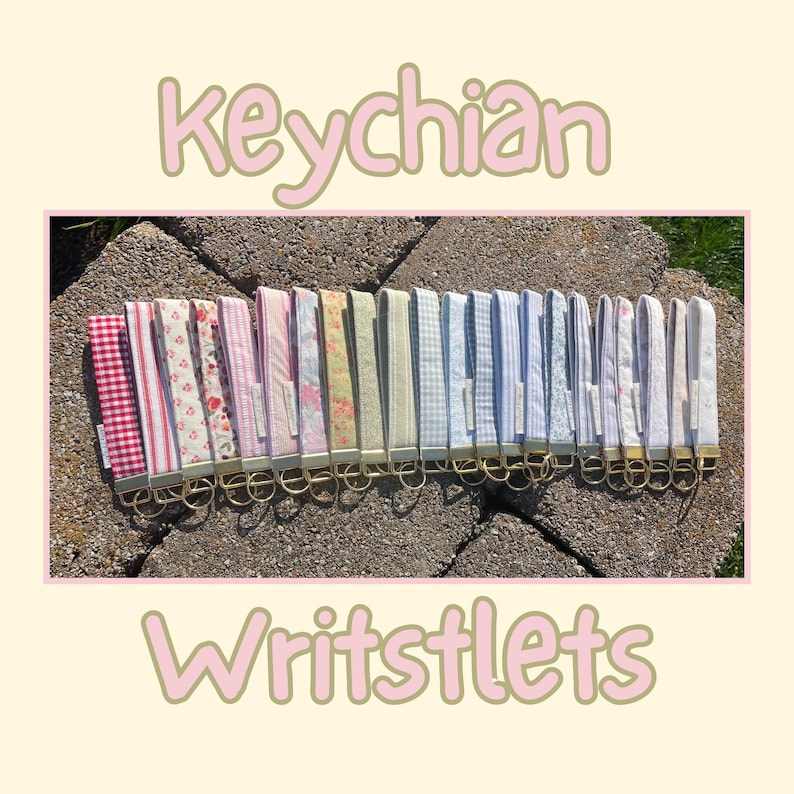 May include: A collection of fabric wristlet keychains featuring various patterns including red gingham, floral prints, stripes, and solid colors. Each keychain has a gold-toned metal clasp and ring. The text "keychain Writstlets" is visible.