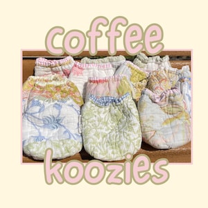 Puede incluir: Una colección de fundas de tela acolchada para café con varios estampados florales y de cuadros en tonos pastel de verde, azul, rosa y amarillo. La palabra Coffee está impresa en letras rosas grandes arriba y Koozies abajo.