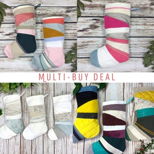 Puede incluir: Una colección de calcetines navideños hechos a mano en varios colores y texturas. Cada calcetín presenta un diseño de patchwork único con telas como rosa, azul, amarillo y blanco. Se muestra el texto "MULTI-BUY DEAL".
