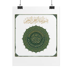 May include: A white wall poster featuring a central dark green circular mandala with intricate gold Arabic calligraphy. Above the mandala, the phrase Bismillah is written in gold. The design is enclosed in a thin gold border with decorative corners.