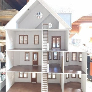 May include: A white dollhouse with four levels, a staircase, and windows. The dollhouse is open and the interior is visible. The floors are brown.