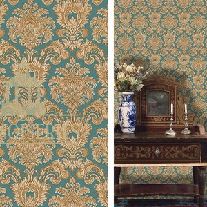 May include: Teal and gold damask wallpaper with a repeating floral pattern. The wallpaper features a classic design with ornate, swirling details. The image also shows a small antique table with a vase and candles.